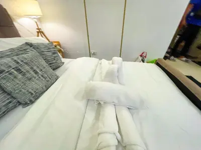 a white bed with white sheets and pillows on it at Cozy & Chic 1BR near Mall of Asia - S Residences in Manila