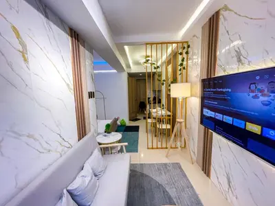 a living room with a large flat screen tv on a wall at Cozy & Chic 1BR near Mall of Asia - S Residences in Manila