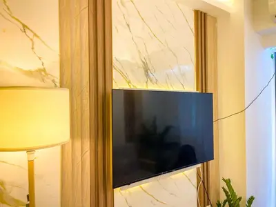 a flat screen tv hanging on a wall at Cozy & Chic 1BR near Mall of Asia - S Residences in Manila