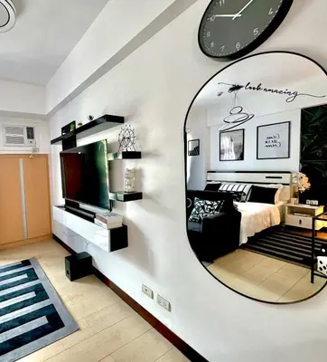 a bedroom with a large mirror on the wall at Pasay Airport Condotel by ASD in Manila