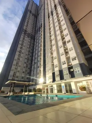 a large building with a pool in front of it at Lil Max Staycation in Manila