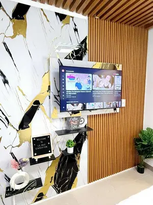 a tv on a wall in a room at Lil Max Staycation in Manila