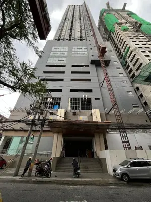 a tall building with a crane on top of it at Lil Max Staycation in Manila