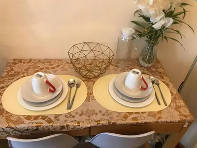 a table with plates and utensils and a vase of flowers at Staycation sa Jazz by Amaya 3921 Tower B in Manila