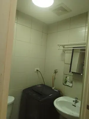 a bathroom with a toilet and a black suitcase at Staycation sa Jazz by Amaya 3921 Tower B in Manila