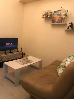 a living room with a couch and a table and a tv at Staycation sa Jazz by Amaya 3921 Tower B in Manila