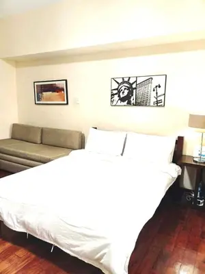 a bedroom with a white bed and a couch at Mosaic Tower in Manila
