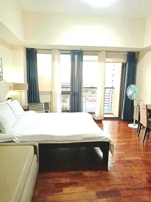 a large bedroom with a large bed and large windows at Mosaic Tower in Manila