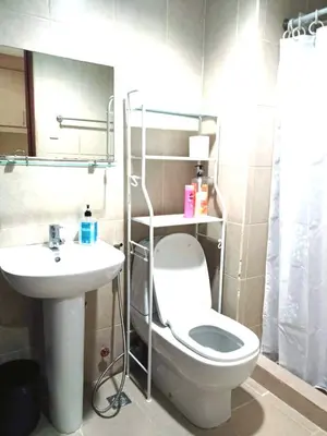 a bathroom with a toilet and a sink at Mosaic Tower in Manila