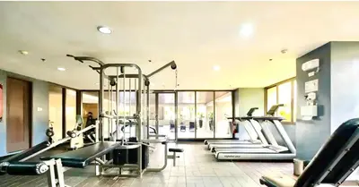 a gym with several treadmills and elliptical machines at Mosaic Tower in Manila