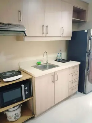 a kitchen with a sink and a microwave at Mosaic Tower in Manila