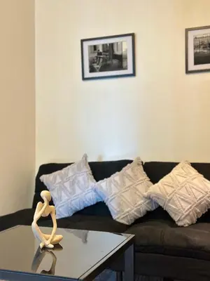 a living room with a black couch and a table at Azure staycation by marco in Manila
