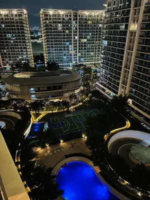 a large building with a tennis court in front of it at Azure staycation by marco in Manila