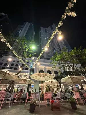 a group of tables and chairs with umbrellas at night at Uptown Parksuite 1 BR Tower 2 BGC Taguig in Manila