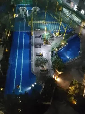 an overhead view of a swimming pool at night at 2BR PIONEER Woodland Boni,Mandaluyong connected to Boni MRT station in Manila