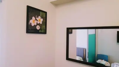 a mirror on a wall with a picture of flowers at Millionaire Makati Brio Tower in Manila