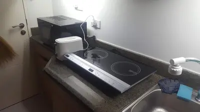 a kitchen counter with a stove and a sink at Millionaire Makati Brio Tower in Manila