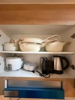 a shelf filled with pots and pans and a pot and a pan at MJM Cityscape at Red Residences in Manila