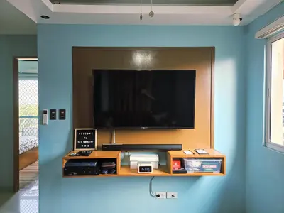a flat screen tv on a blue wall at Spacious & Cozy 1-Bedroom, Sleeps 2-4 in Manila