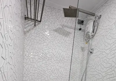 a bathroom with a shower with a toilet and a mirror at Spacious & Cozy 1-Bedroom, Sleeps 2-4 in Manila
