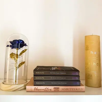 a stack of books and a vase on a shelf at Crizzy's Hub Sariel at Shore Residences - 1BR with Netflix and Disney - Near MOA in Manila