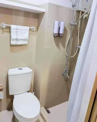 a bathroom with a toilet and a shower at Crizzy's Hub Sariel at Shore Residences - 1BR with Netflix and Disney - Near MOA in Manila