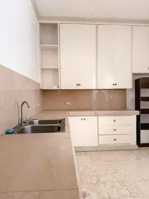 a kitchen with white cabinets and a sink at 6-Bedroom Duplex with pool near NAIA in Manila