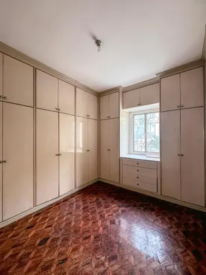 an empty room with white cabinets and a window at 6-Bedroom Duplex with pool near NAIA in Manila