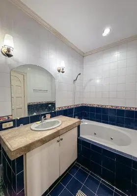 a bathroom with a sink and a tub and a mirror at 6-Bedroom Duplex with pool near NAIA in Manila