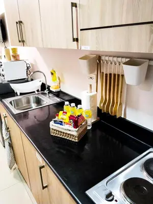 a kitchen with a sink and a black counter top at Crizzy's Hub Gabrielle at Shore Residences in Manila