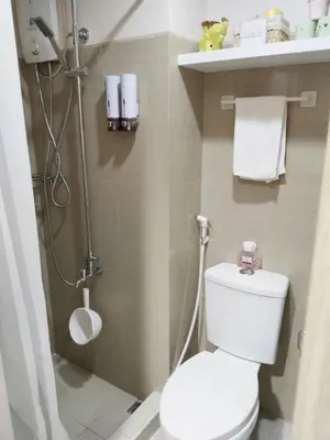 a small bathroom with a toilet and a shower at Crizzy's Hub Gabrielle at Shore Residences in Manila