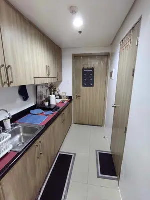 a small kitchen with a sink and a door at Mall of Asia's Staycation in Manila