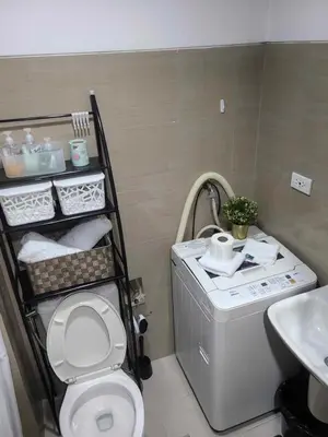 a bathroom with a white toilet and a sink at Mall of Asia's Staycation in Manila