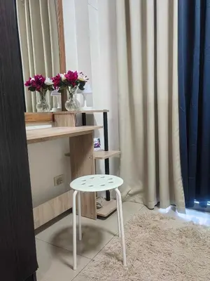 a white stool next to a table with flowers on it at Mall of Asia's Staycation in Manila