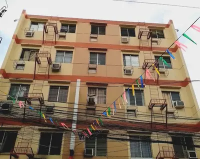 a tall building with colorful flags in front of it at Circuit Suites in Manila