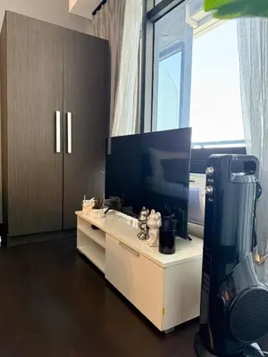 a room with a tv and a desk with a hair dryer at Sky-High Studio with Netflix, Sunset View, and Disney in Manila