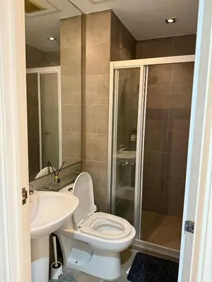 a bathroom with a toilet and a sink and a shower at Sky-High Studio with Netflix, Sunset View, and Disney in Manila