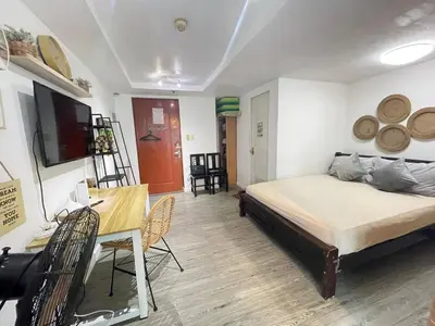 a bedroom with a bed and a table and a desk at Ortigas Condotel near Robinsons Galleria with free pool in Manila