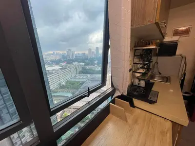 a kitchen with a large window with a view of a city at ADB Avenue Tower GOOD FOR 5 PAX in Manila