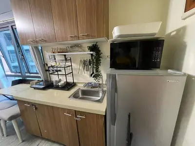 a kitchen with a sink and a microwave and a refrigerator at ADB Avenue Tower GOOD FOR 5 PAX in Manila