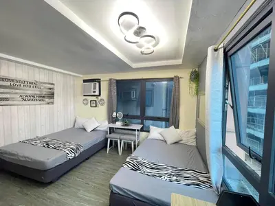 a room with two beds and a table in it at ADB Avenue Tower GOOD FOR 5 PAX in Manila