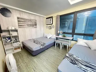 a small room with two beds and a desk at ADB Avenue Tower GOOD FOR 5 PAX in Manila