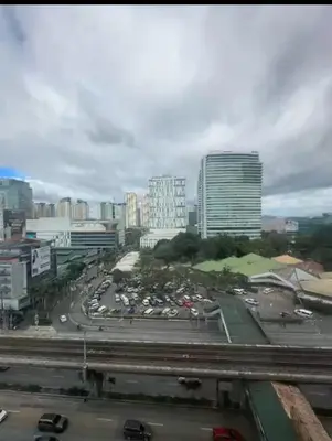a city with a lot of cars in a parking lot at Deca Cubao Budget Condo by Ashti in Manila