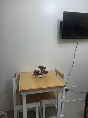 a wooden table with a plant on top of it at Deca Cubao Budget Condo by Ashti in Manila