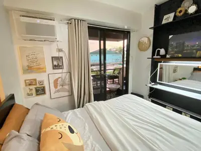 a bedroom with a bed with a television and a balcony at East Raya Gardens Pasig near Ortigas BGC Eastwood in Manila