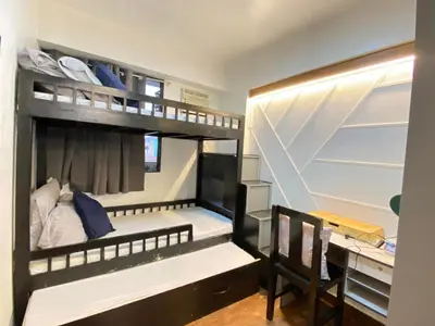 a room with two bunk beds and a desk at East Raya Gardens Pasig near Ortigas BGC Eastwood in Manila