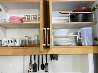 a kitchen cabinet with dishes and utensils in it at East Raya Gardens Pasig near Ortigas BGC Eastwood in Manila