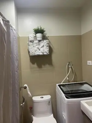 a bathroom with a toilet and a plant on a shelf at Gen Travel Hub in Manila