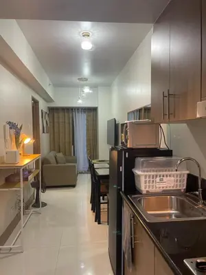 a kitchen with a sink and a living room at Gen Travel Hub in Manila
