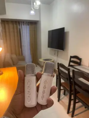 a person holding two microphones in a living room at Gen Travel Hub in Manila